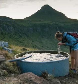 Randonneuse en train de boire dans la chaîne des Puys
